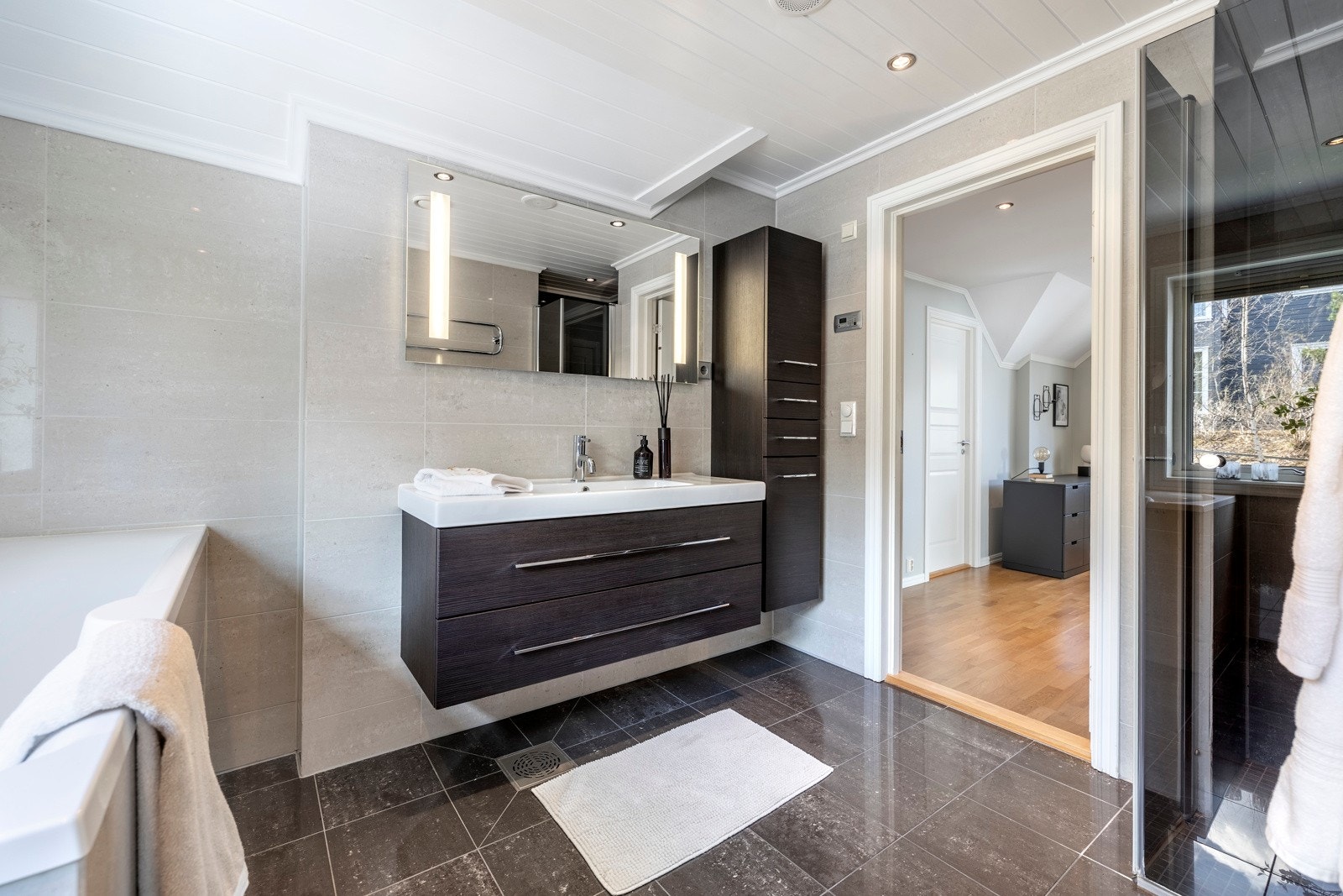 Badet er pent innredet med downlights, fliser og vannbåren gulvvarme. Galleribilde