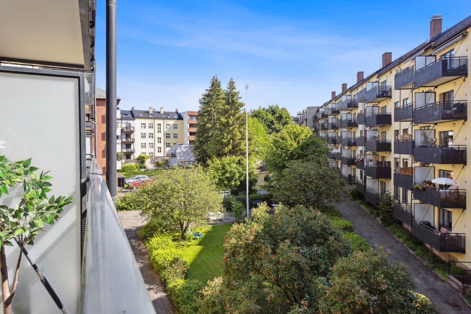 Balkongen vender ut mot en hyggelig og frodig bakgård. Galleribilde