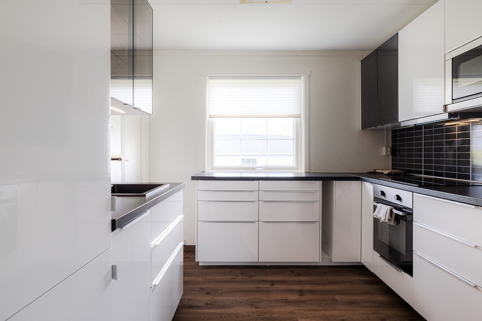 Kjøkken med integrerte hvitevarer med keramisk komfyrtopp, steikeovn, mikrobølgeovn, og oppvaskmaskin. Bod innenfor kjøkkenet til venstre på bildet. Se planskisse Galleribilde