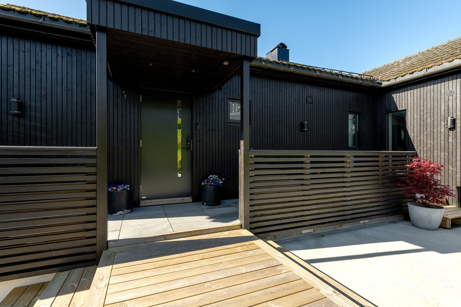 Moderne, stilfull fasade med svart stående bordkledning Galleribilde