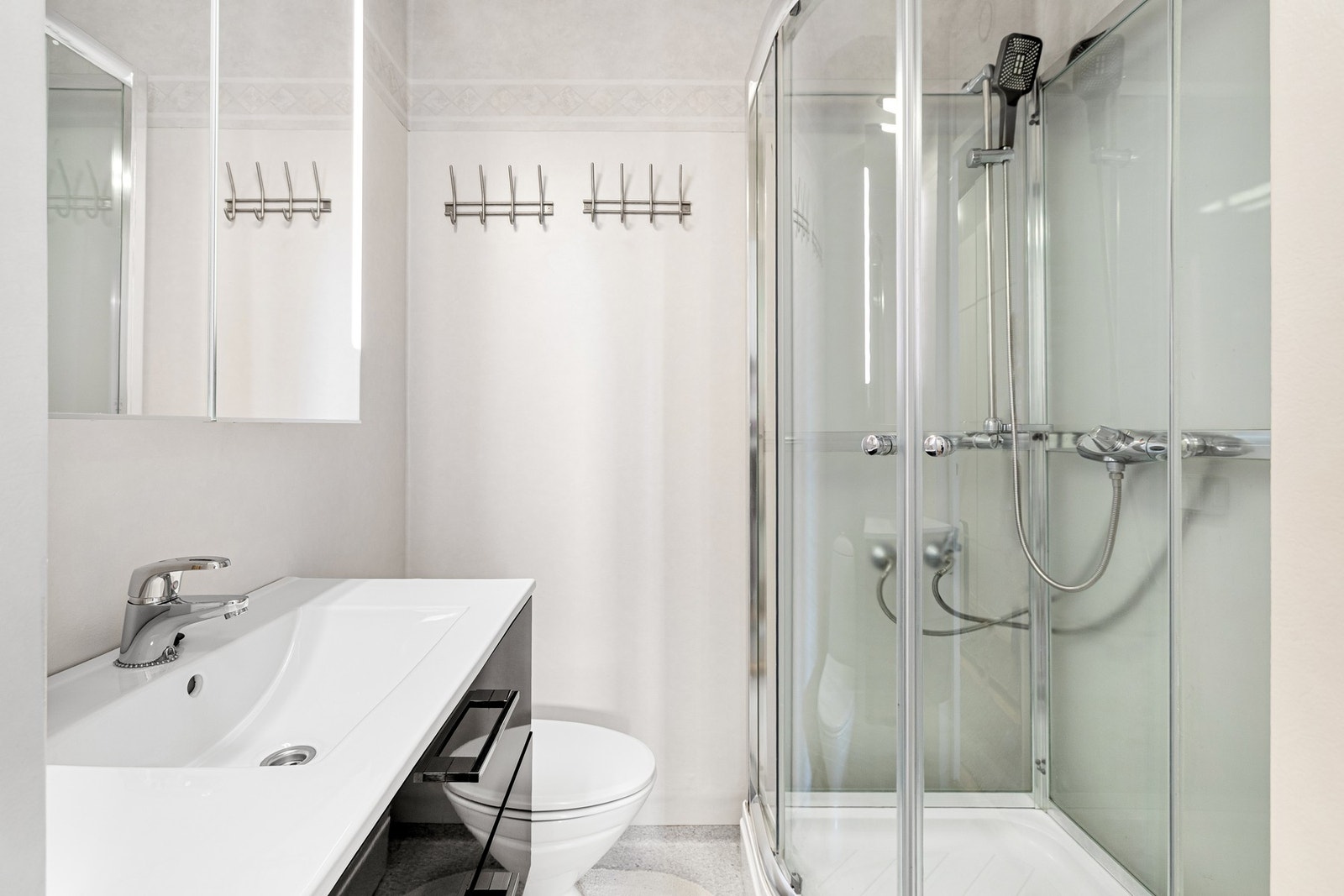 Badet har plass til det nødvendige med servant i skap, toalett og dusjkabinett. Galleribilde