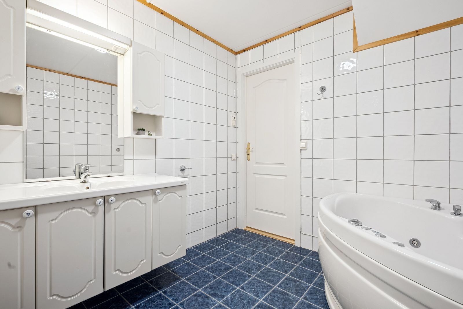 Romslig baderom med varme i gulv, lys profilert innredning og badekar. Galleribilde