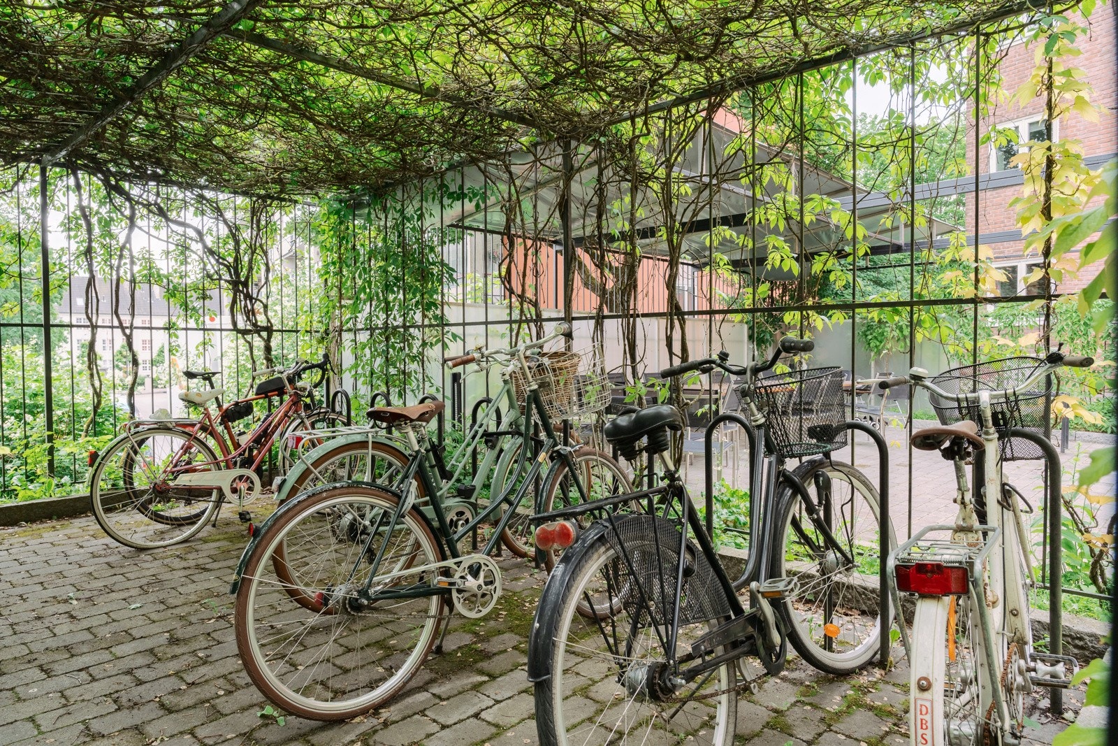 Låst sykkelskur i bakgården. Det er også et fellesvaskeri og tørkerom i kjeller med nye maskiner fra 2025. Galleribilde