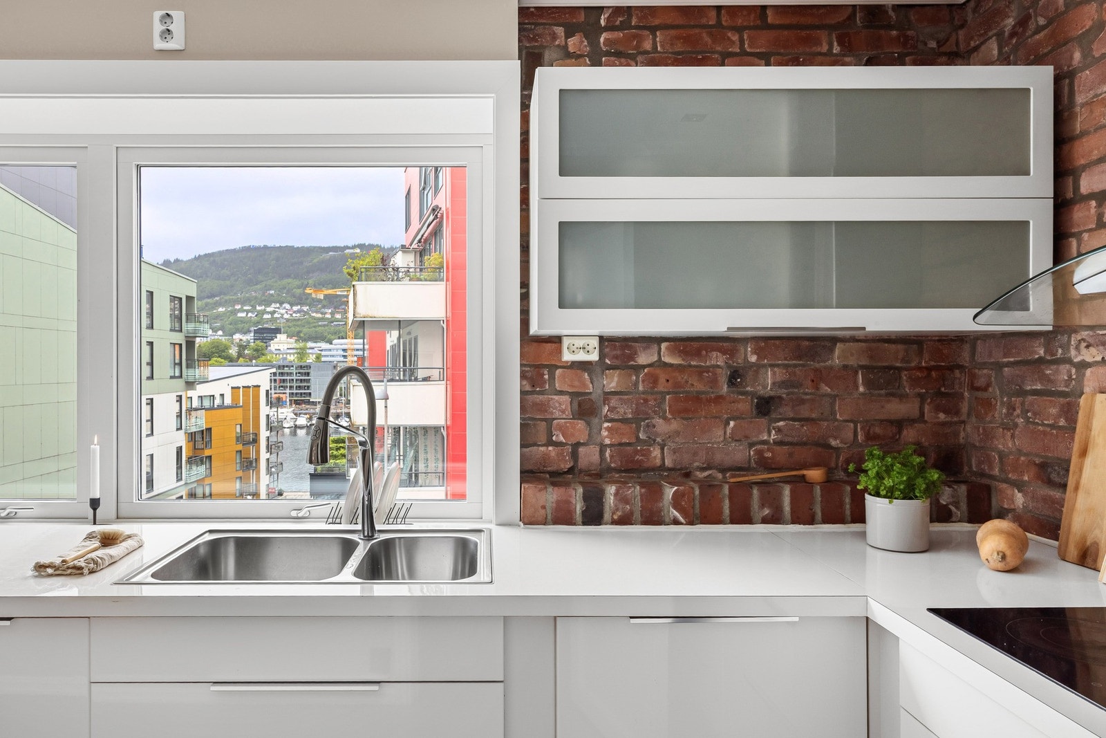 Innredningen har slette fronter og laminat benkeplate med nedfelt vask av stål. Galleribilde