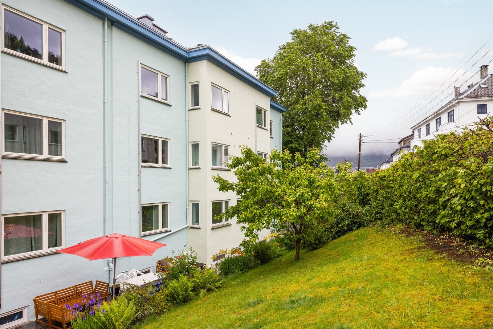 Stor felles hage på baksiden av bygget. Fasaden ble renovert med nye vinduer i 2023. Galleribilde