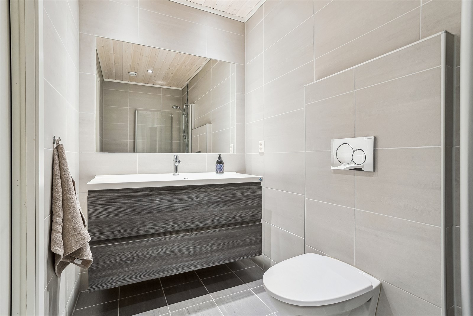 Pent baderom nr. 2. Innredet med vegghengt toalett, servant med skuffeseksjon samt speil. Galleribilde