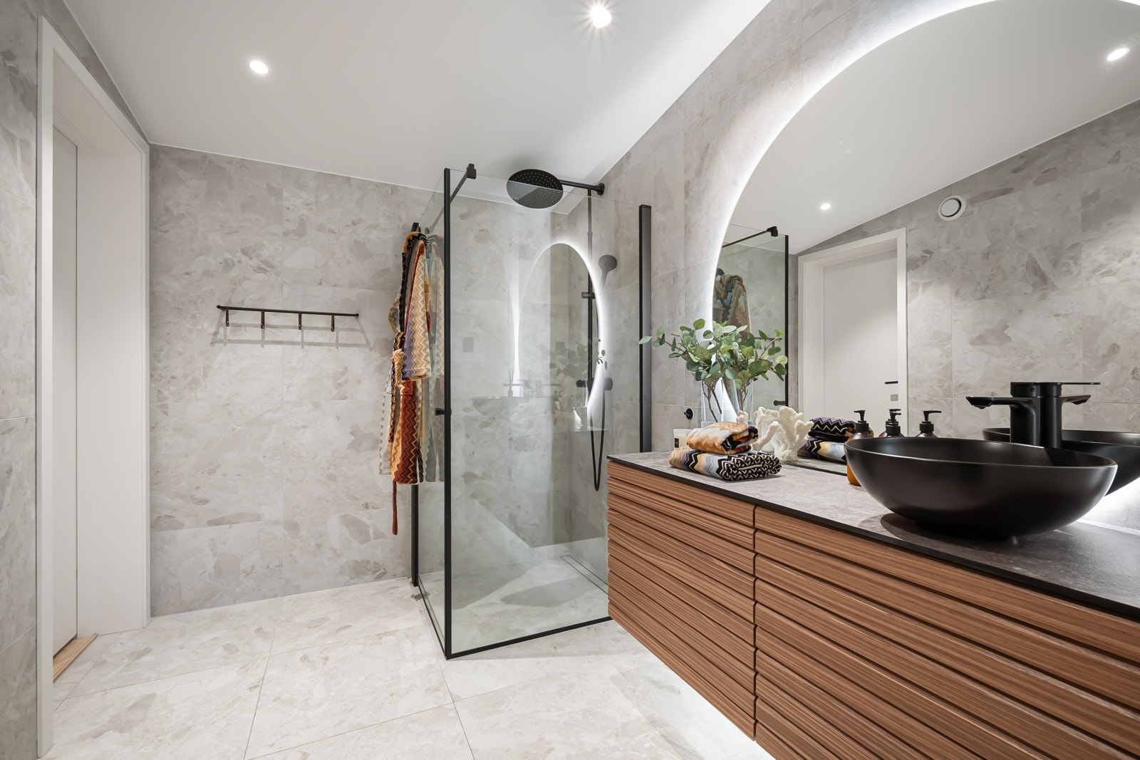 Baderommet er utstyrt med romslig dusjnisje med regnfallsdusj og håndholdt dusj, veggmontert klosett og bolleservant på bred innredning. Galleribilde