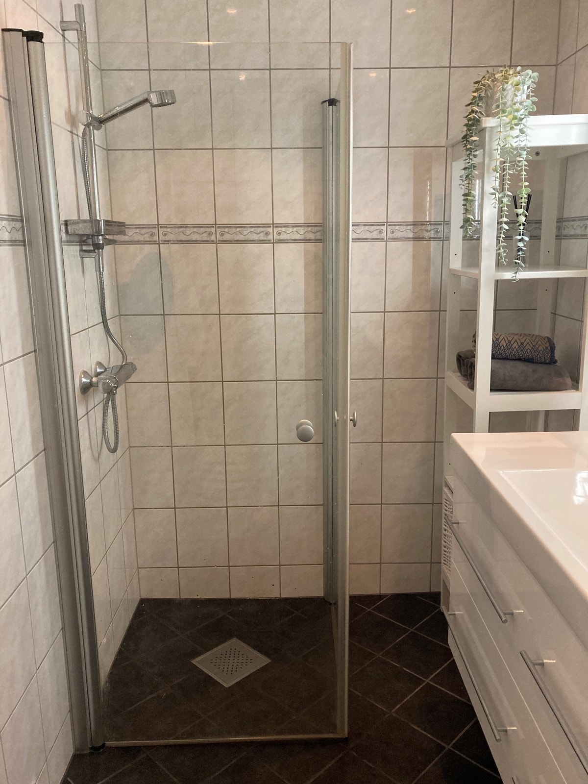 Badet er helfliset og inneholder dusj, servant, oppbevaring og vaskemaskin. Galleribilde