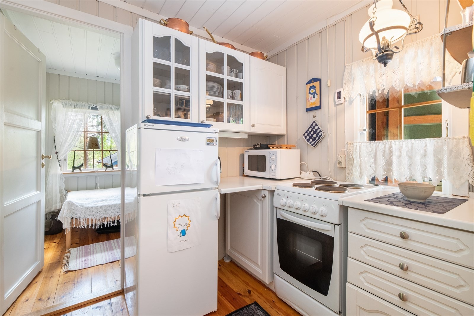 Kjøkkenet ligger praktisk til med tilknytning til stuen via åpen tilkomst. Her er det innredning med hvite, profilerte fronter, laminat benkeplater med nedfelt utslagsvask og opplegg for komfyr og kjøleskap. Galleribilde