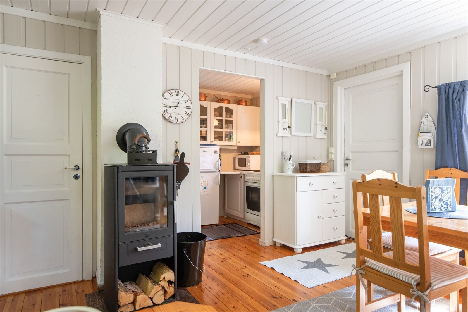 Det er god plass til både sofagruppe og spisestue, og sentralt i rommet er det satt inn en ny vedovn i 2022 som gir god varme på kalde dager. Galleribilde