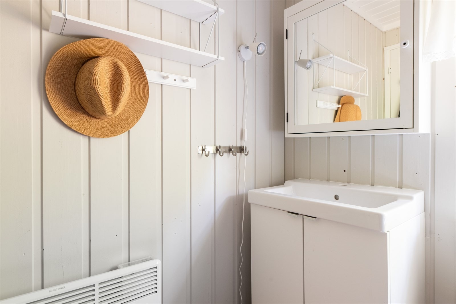 Her er det også innredet med en servantinnredning med underskap og speilskap over utslagsvasken. Galleribilde