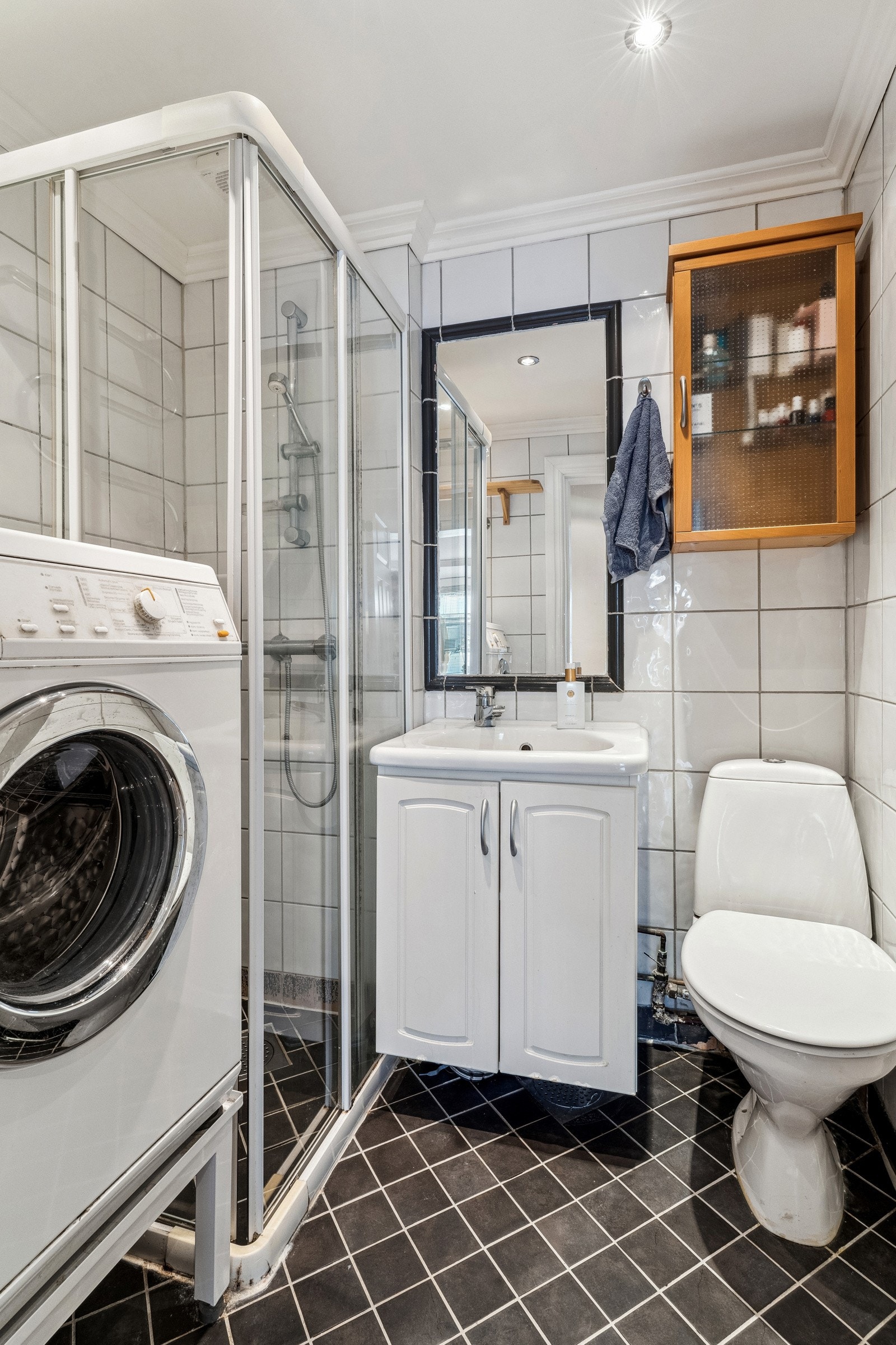 Flislagt bad fra antatt år 1999. Baderomsinnredningen er bestående av servant med underskap, inn fliset speil, gulvmontert klosett, dusjhjørne med skyvedører og opplegg for vaskemaskin. Galleribilde