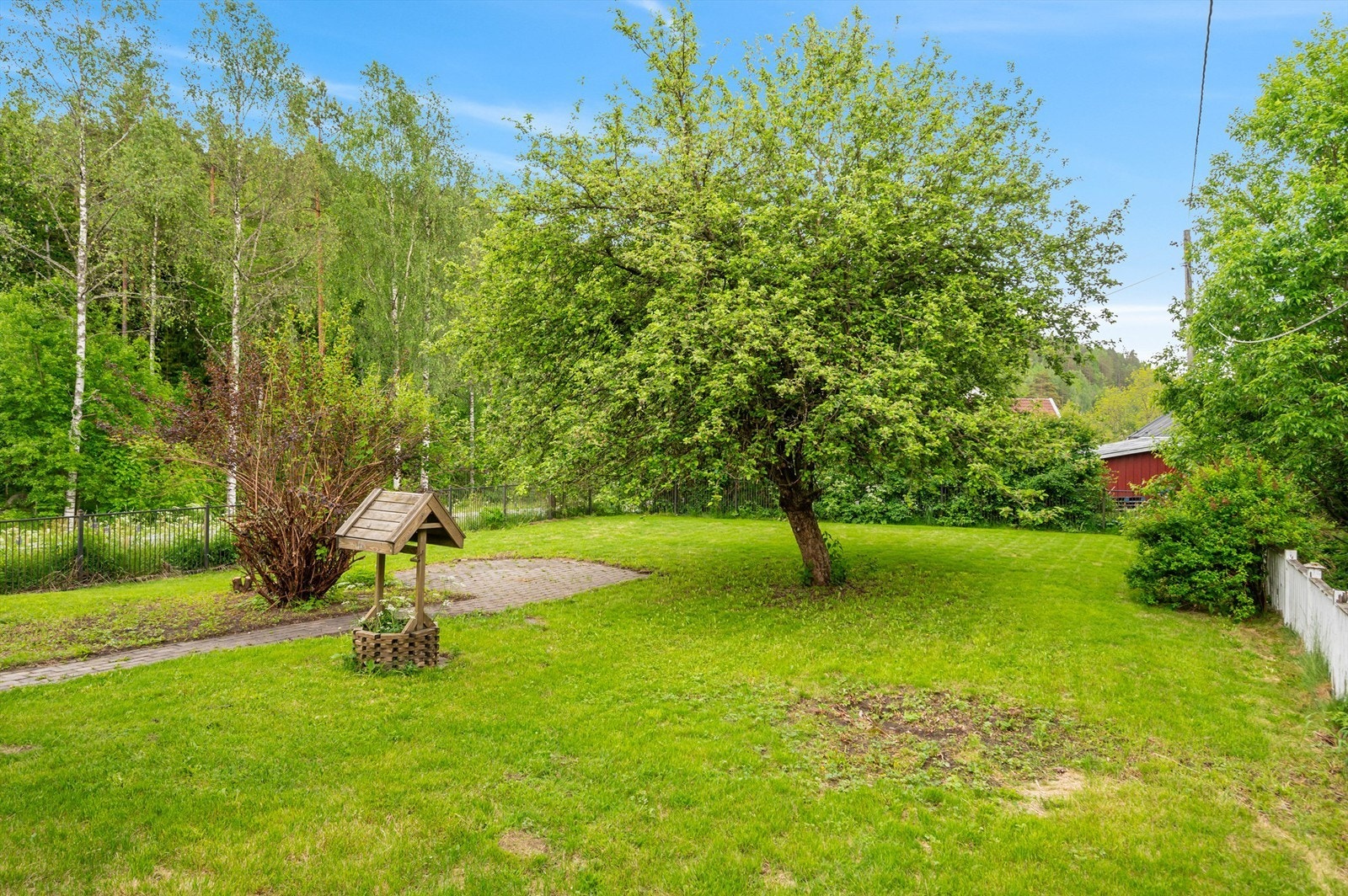 Stor, solrik og fin hage med opparbeidede plenarealer, frukttrær og variert beplantning. God plass til lek, dyrking eller avslapning i grønne omgivelser.. Galleribilde