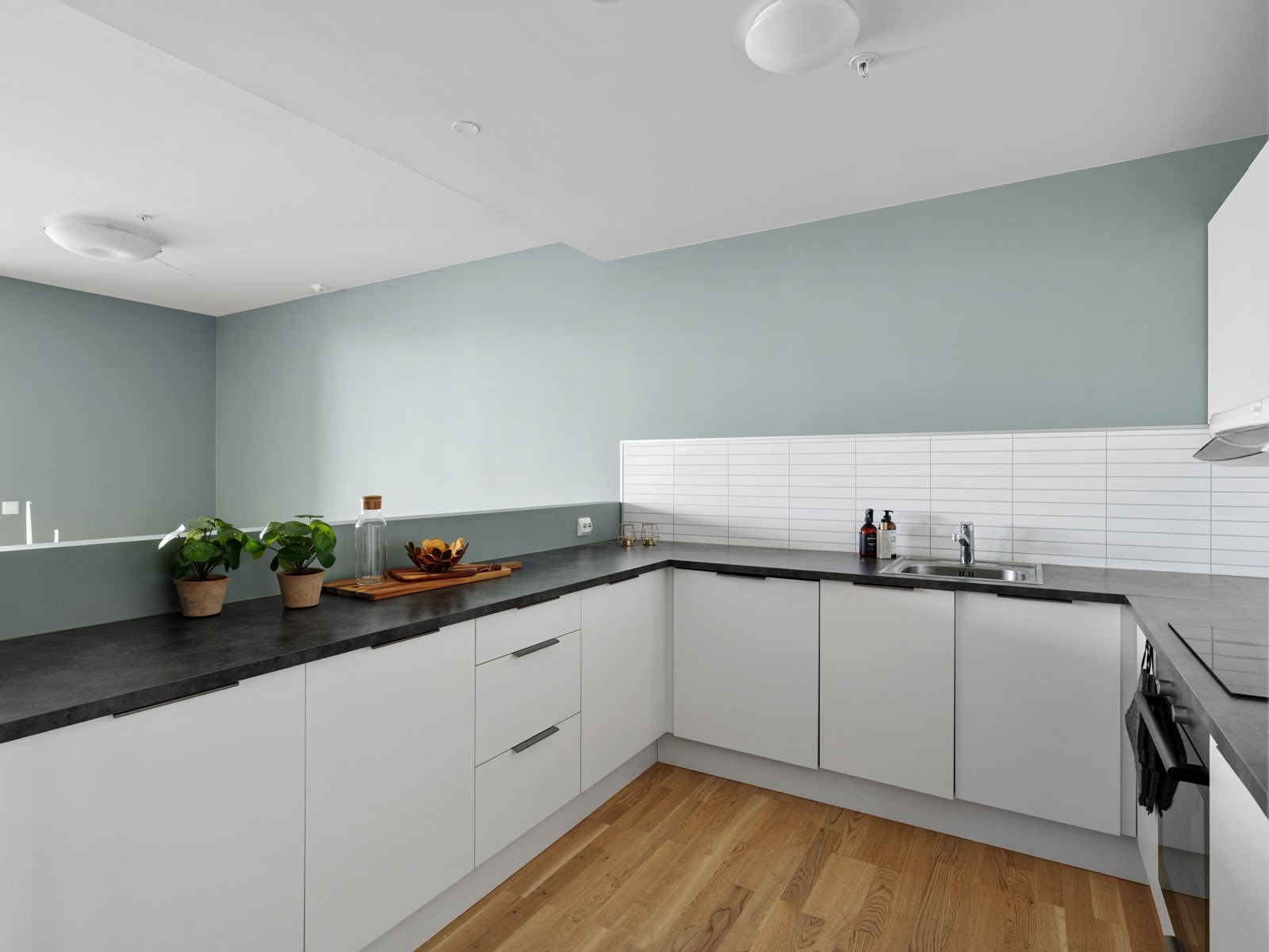 Kjøkkeninnredning har et stilig design med en kombinasjon av glatte fronter og laminat benkeplate. Galleribilde