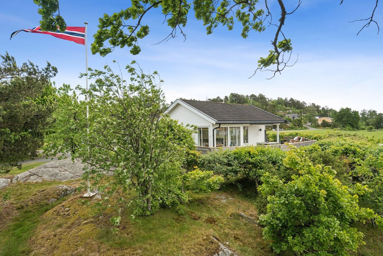 Her på hytta kan du heise flagget! Den andre siden av hytta byr på mer naturtomt. Galleribilde