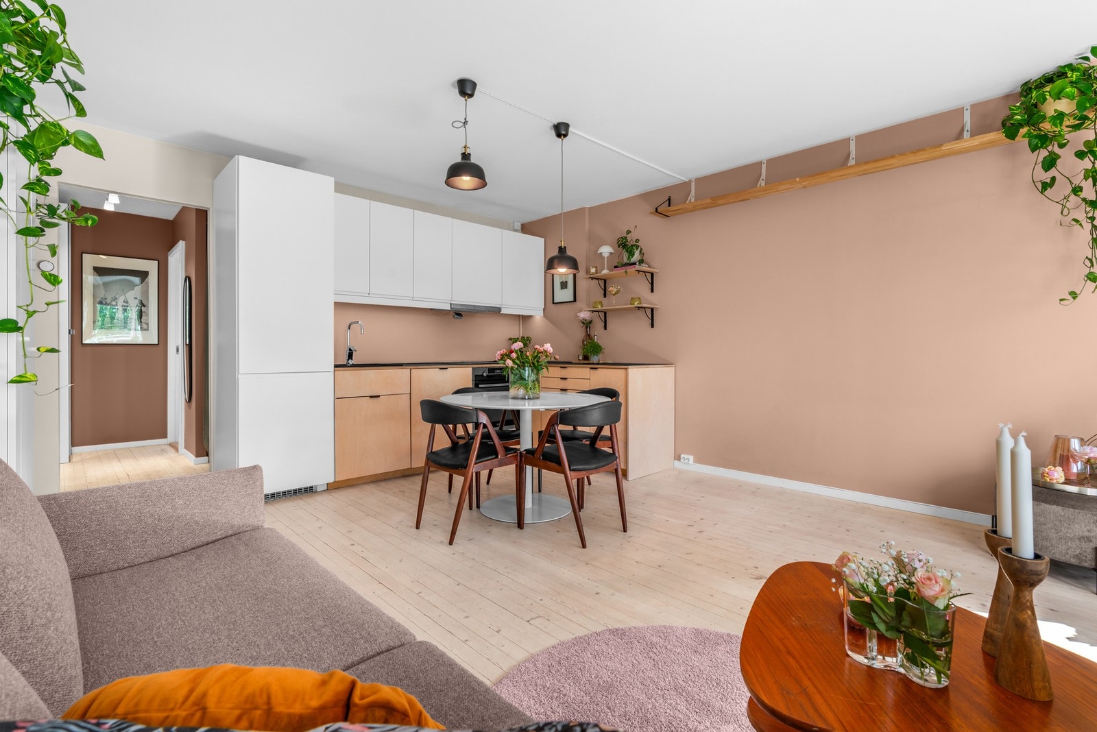 Leiligheten har en romslig og lys stue som ligger i åpen løsning mot kjøkkenet. Her er det sjarmerende, originale tre-gulv som er slipt, samt slette vegger malt i moderne farger. Galleribilde