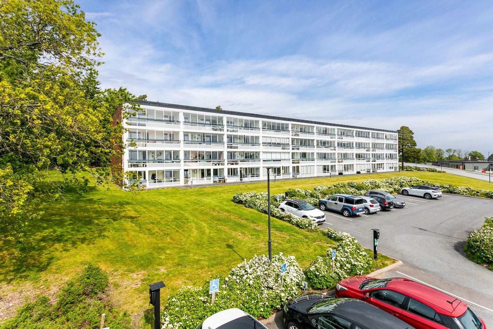 Borettslaget har felles parkeringsområde med biloppstillingsmulighet og ladepunkter for beboerne. Galleribilde