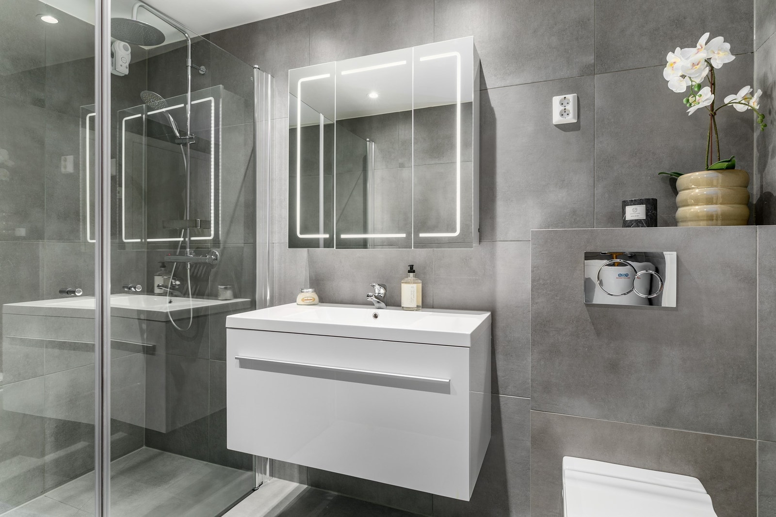 Badet ble renovert i 2020. Grå fliser av storformat på både gulv og vegger fremmer helhet. Gulvet har også varme. Galleribilde