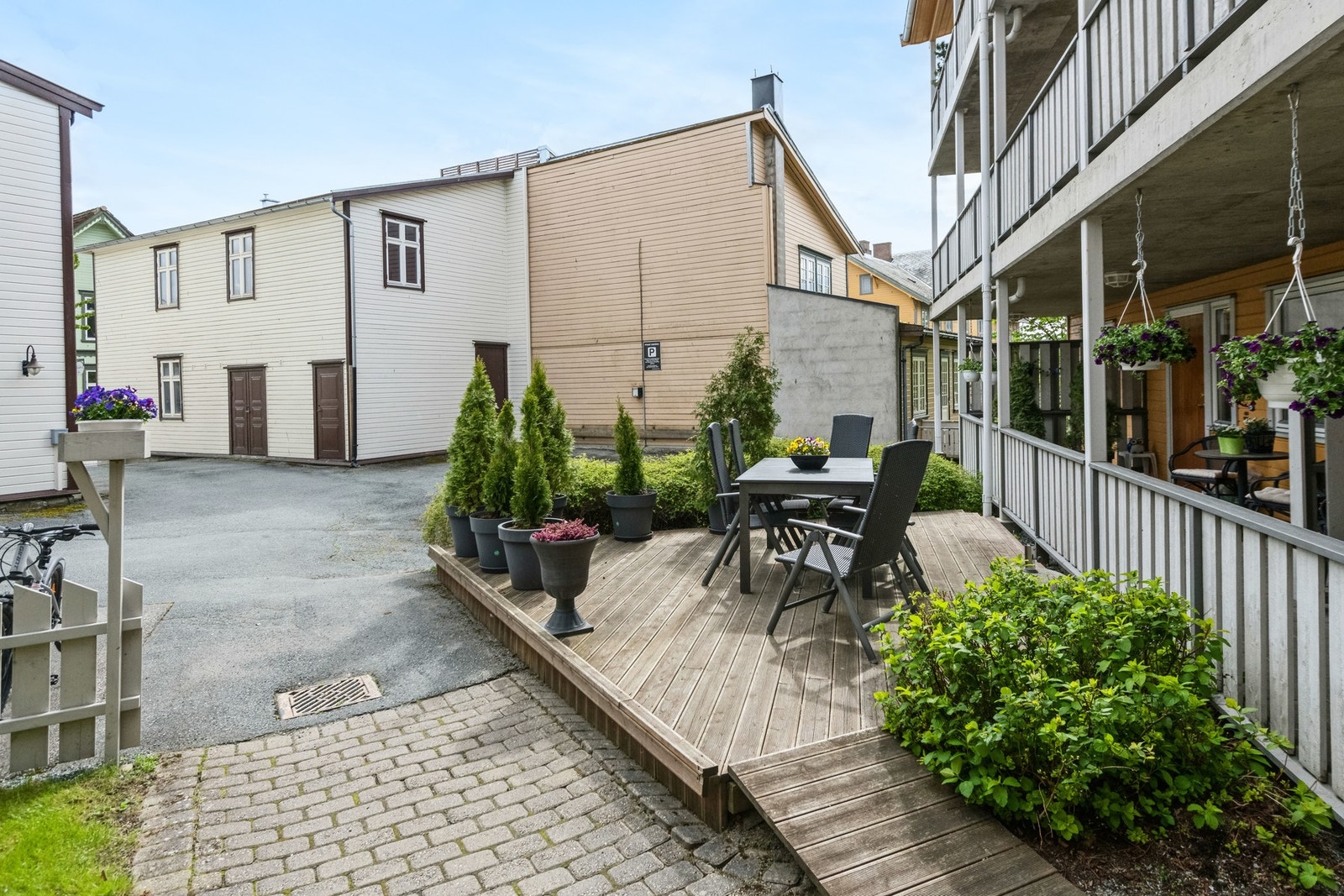 Felleseiet tomt for sameiet som er opparbeidet med prydbusker, asfaltert bakgård og felles markterrasse. Galleribilde