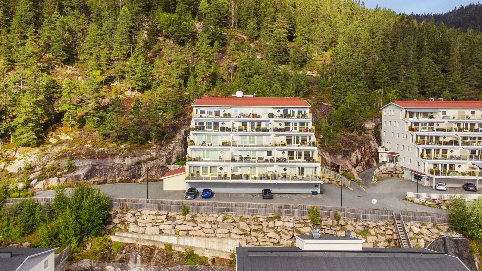 Gjesteparkering, delvis under tak, foran bygget. Galleribilde