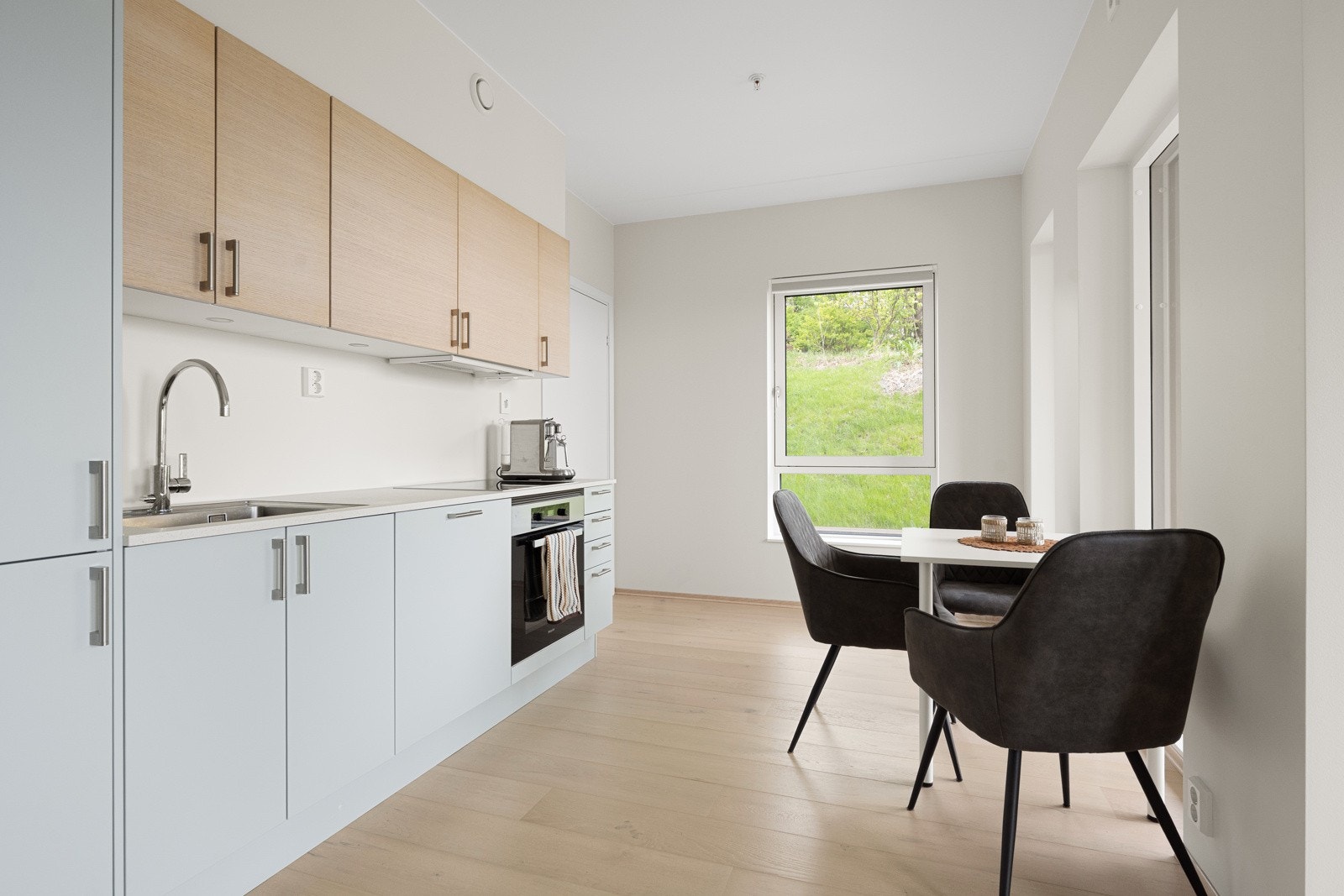 Kjøkkenet ligger i åpen løsning mot stuen og har integrerte hvitevarer fra Miele. Det lekre eikegulvet og fargevalget underbygger en nordisk stil. Galleribilde