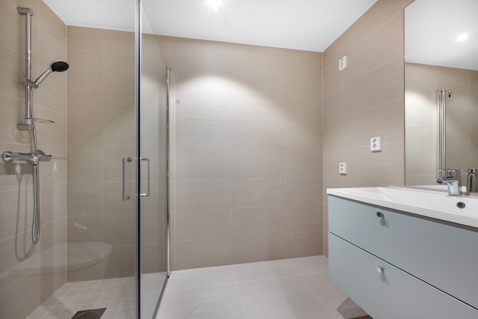 Badet har store lekre fliser, varmekabler og opplegg for vaskemaskin og tørketrommel. Galleribilde