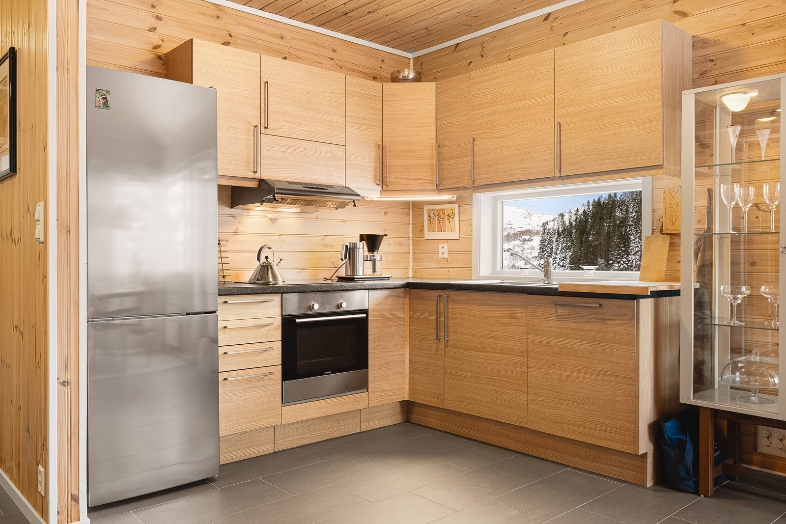 Kjøkkeninnredning har glatte fronter i "natur" farger med benkeplate i laminat. Fint kjøkkenvindu for lysinnslipp gir en herlig atmosfære også her. Galleribilde