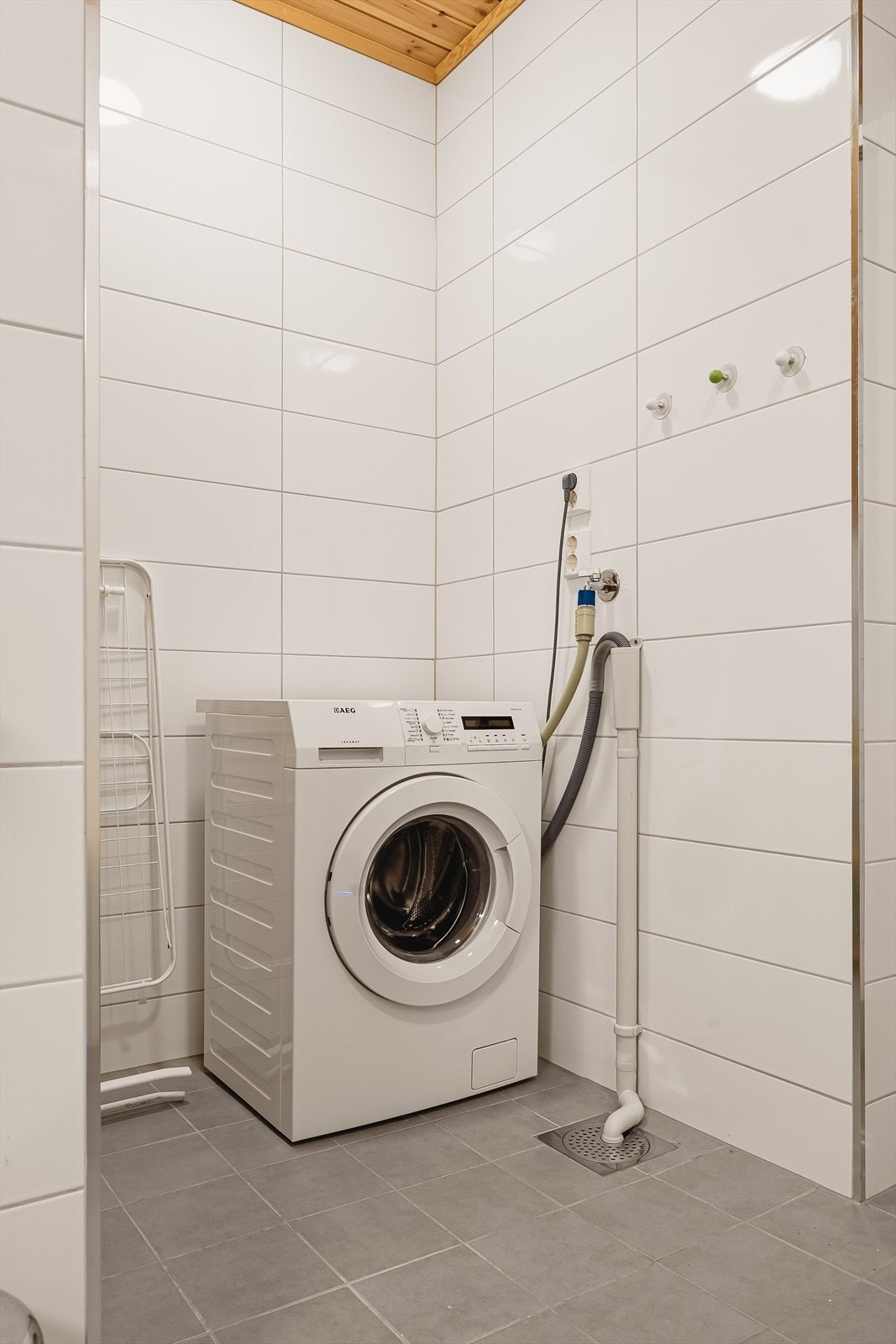Opplegg for vaskemaskin, som står litt adskilt i nisje i rommet. Her er det også plass til tørketrommel, samt til klesstativ mv. Galleribilde