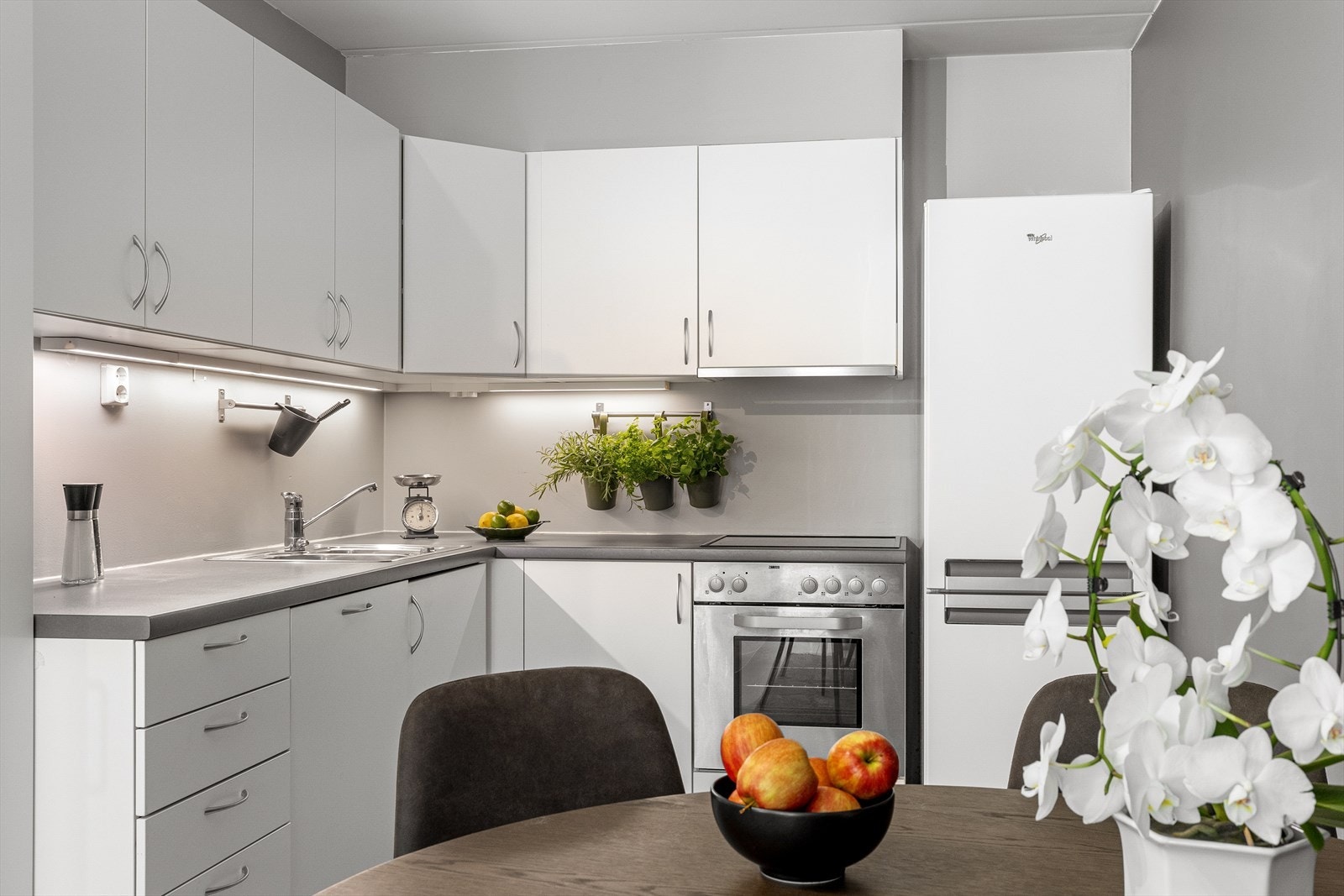 Kjøkkenet har glatte fronter, belysning under overskap, laminat benkeplate og integrerte hvitevarer. Nytt høyskap i 2024. Galleribilde