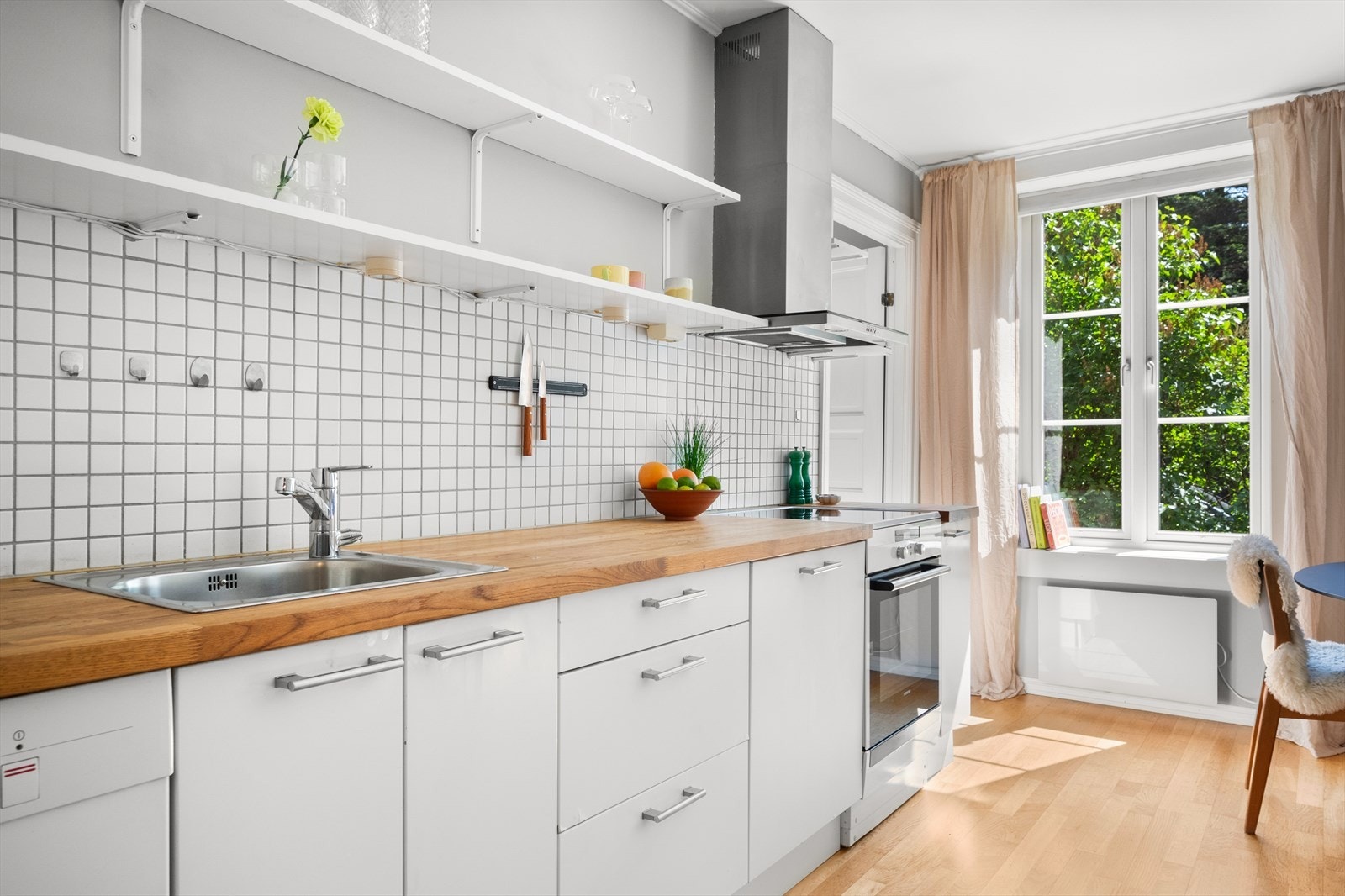 Kjøkkenet har frittstående hvitevarer med avsatt plass til oppvaskmaskin, komfyr og kjøleskap. Kullfilterventilator over kokeplass. Galleribilde