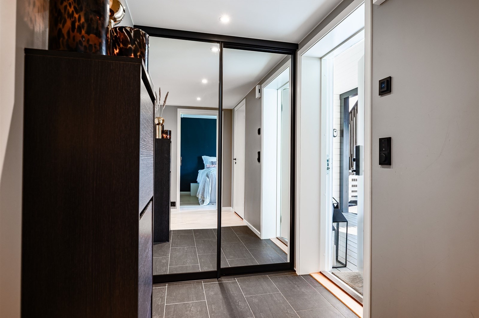 Når du entrer leiligheten kommer du inn i en flott entré med god oppbevaringsplass i stor plassbygget skyvedørsgarderobe med speildører. Entréen har mørke fliser på gulv med gulvvarme og downlights i himlingen. Galleribilde