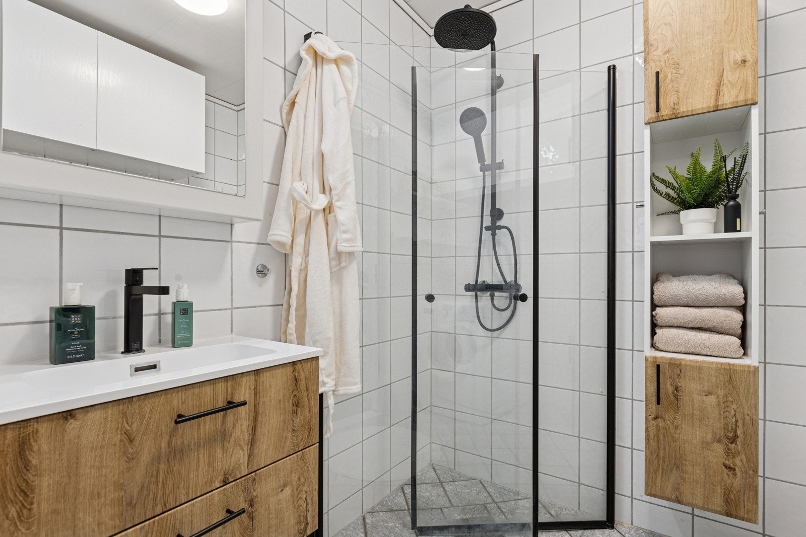 Badet er flislagt og har varme i gulvet. Det er oppgradert med ny innredning og dusjløsning hvor dempet sort går igjen som "rød tråd". Galleribilde