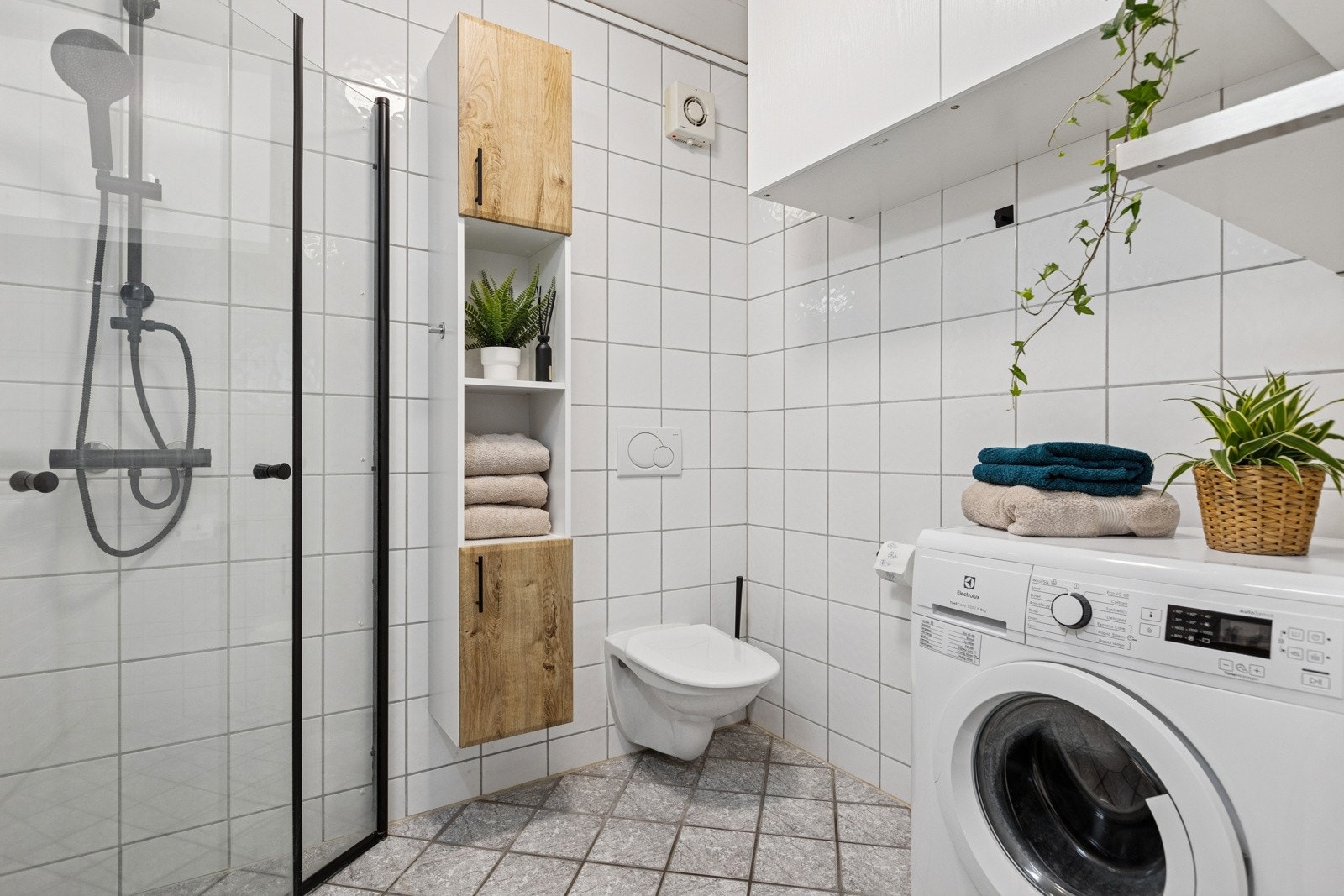 Badet er forøvrig utstyrt med vegghengt klosett, servant, byr på opplegg for vaskemaskin og rikelig med oppbevaringsplass i vegghengte skapløsninger. Galleribilde