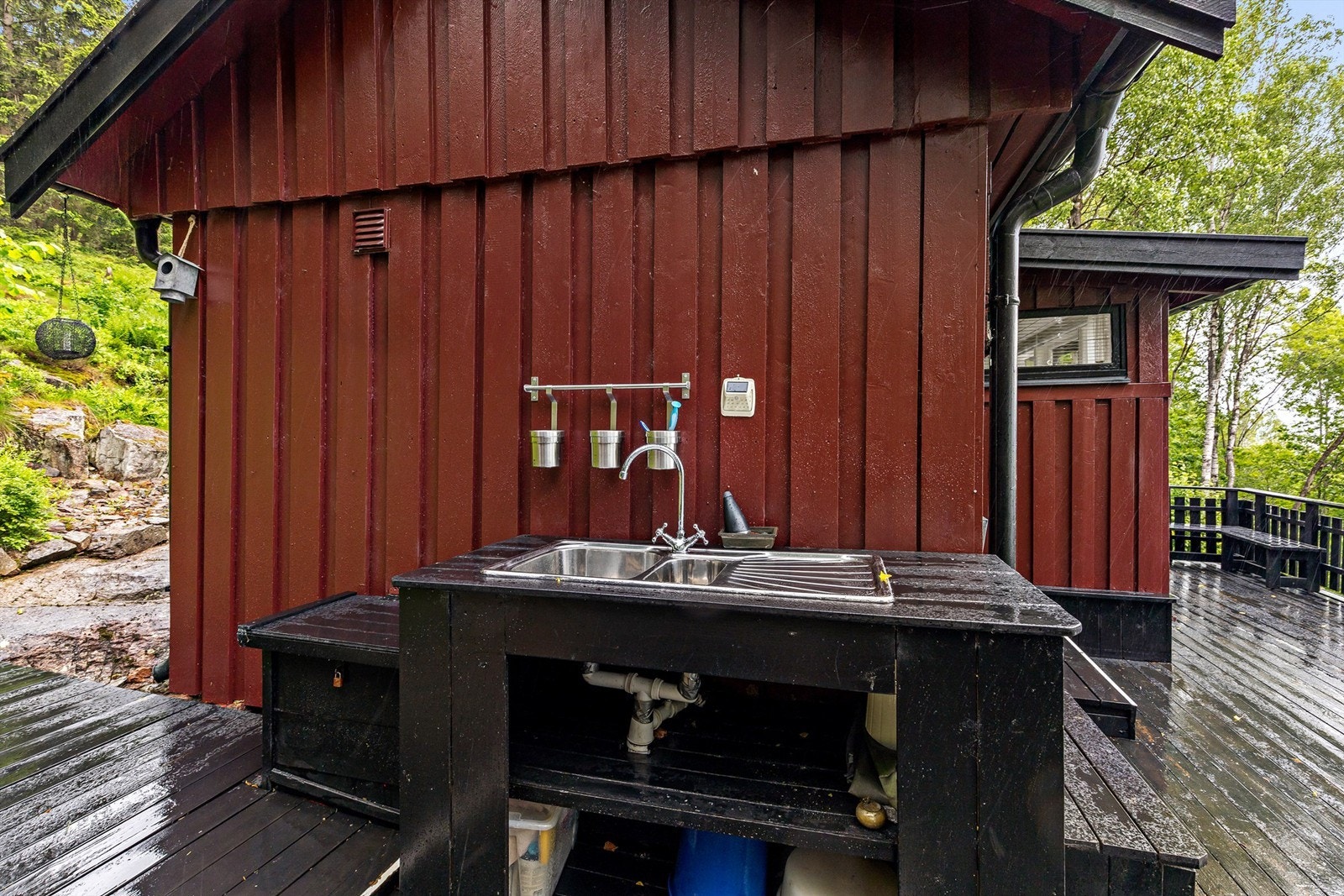 Det er lagt inn sommervann inntil hytteveggen - i tilknytning til dette er det en gulvstående benk med oppvaskkum Galleribilde