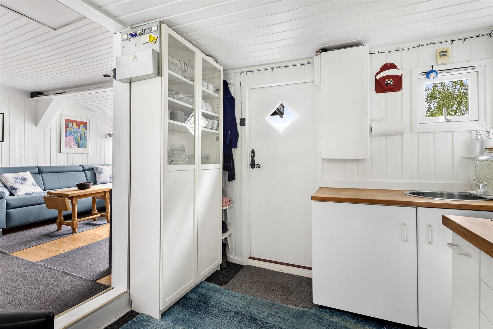 Kjøkkeninnredning med over- og underskap i hvit samt glatt utførelse - Rommet er opprinnelig byggemeldt som gang og bod Galleribilde