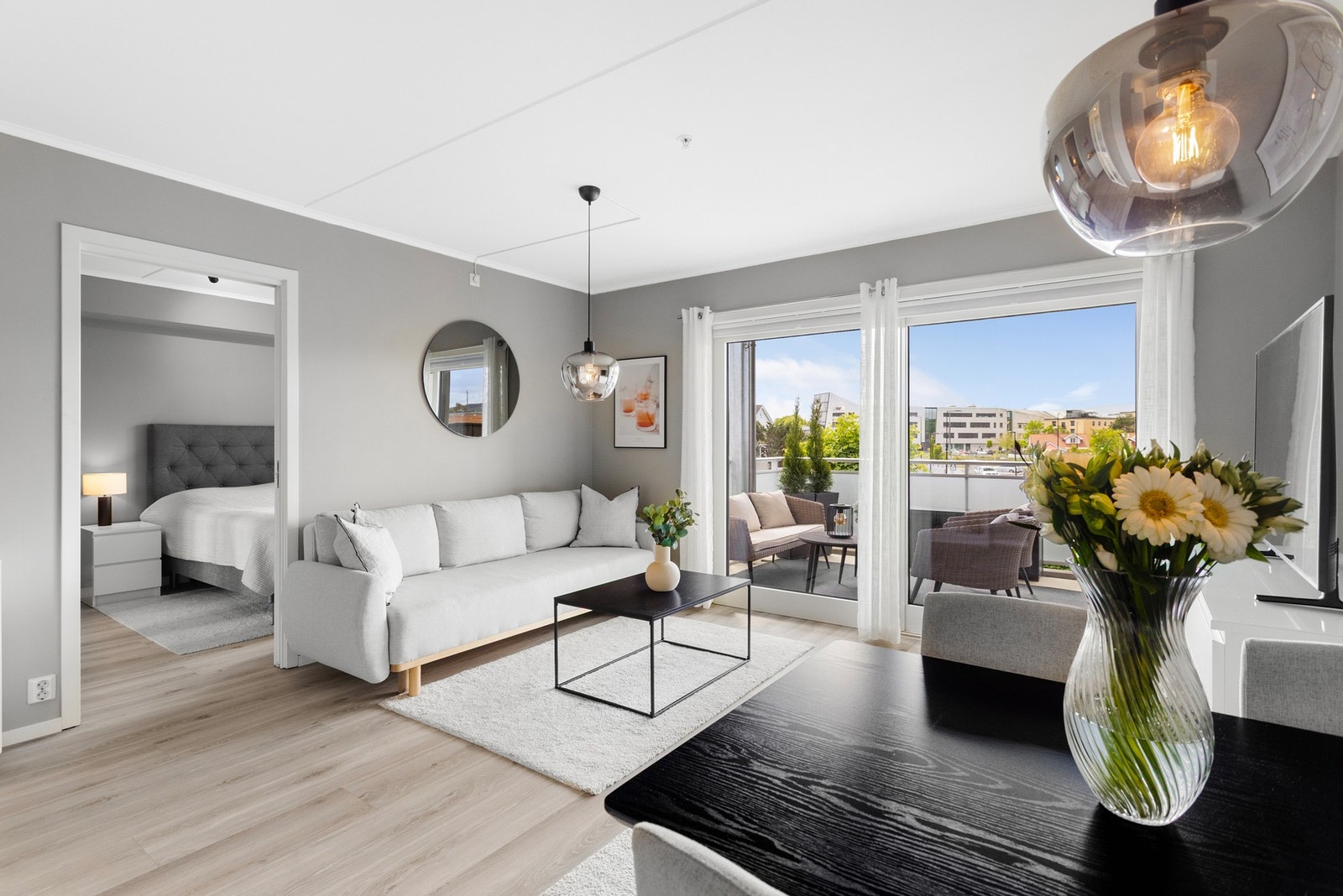 Stuen er lys og trivelig med god plass til både sofa- og spisegruppe, malte veggflater i tidsriktige farger og laminat på gulv Galleribilde