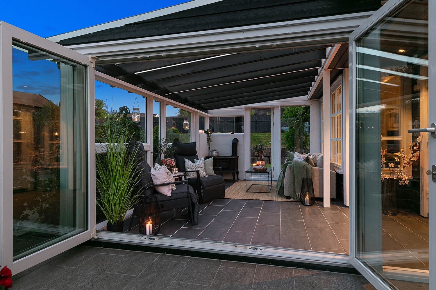 Stor vinterhage med dører ut til terrasse og hagen / Kveldsfoto Galleribilde