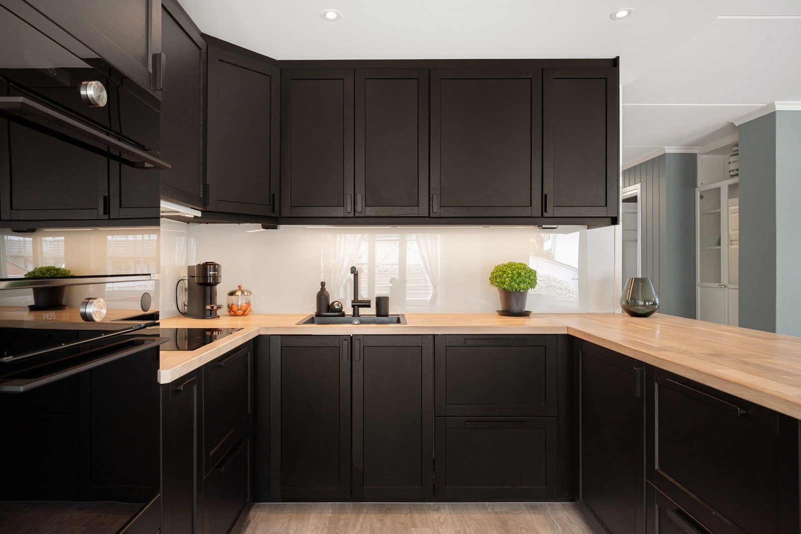 Integrerte hvitevarer som induksjonstopp, oppvaskmaskin, stekeovn, mikro og kjøl/frys. Galleribilde