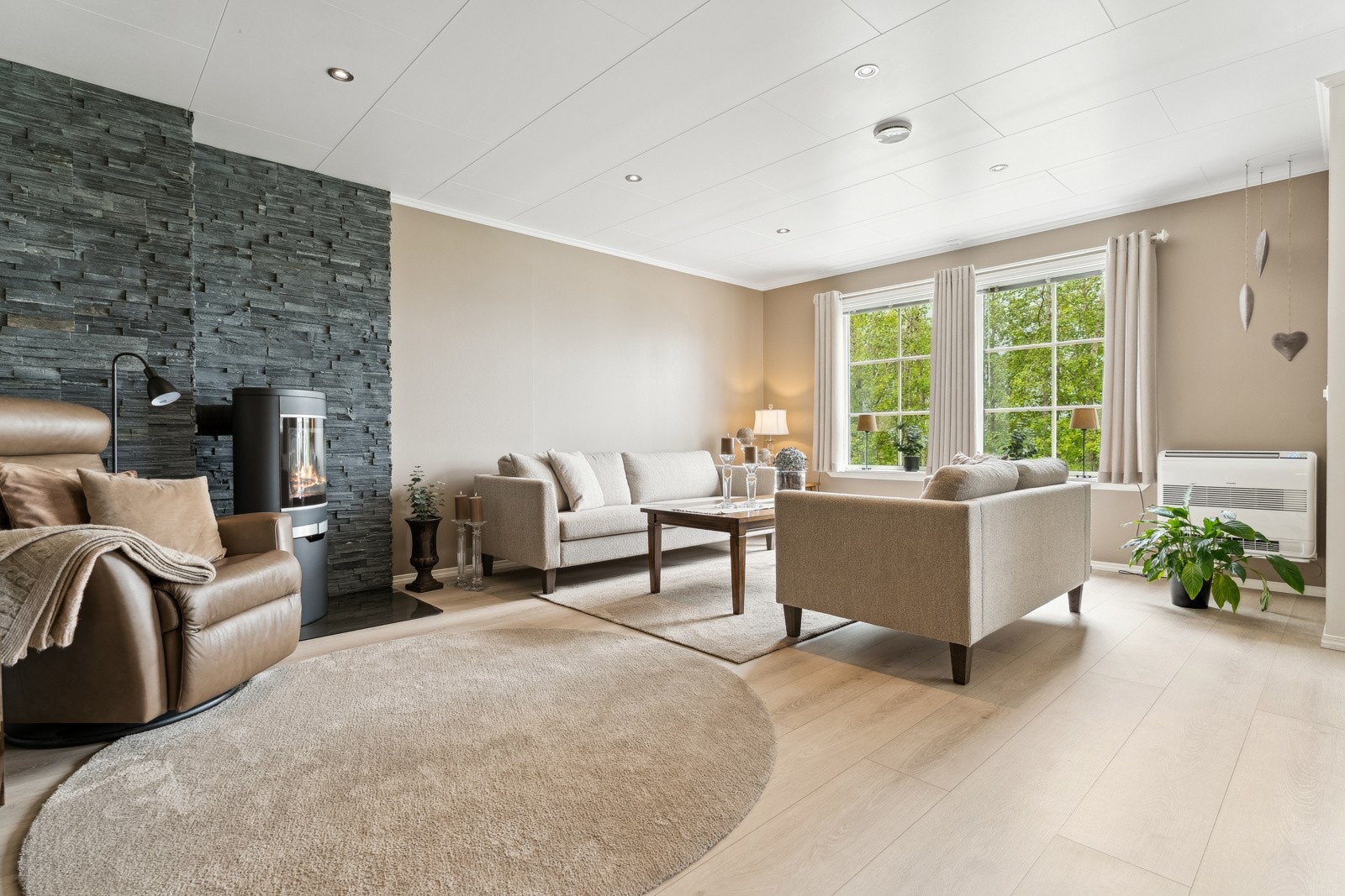 Romsleg og tiltalande stove med lyse overflater og downlightsbelysning i himling Galleribilde