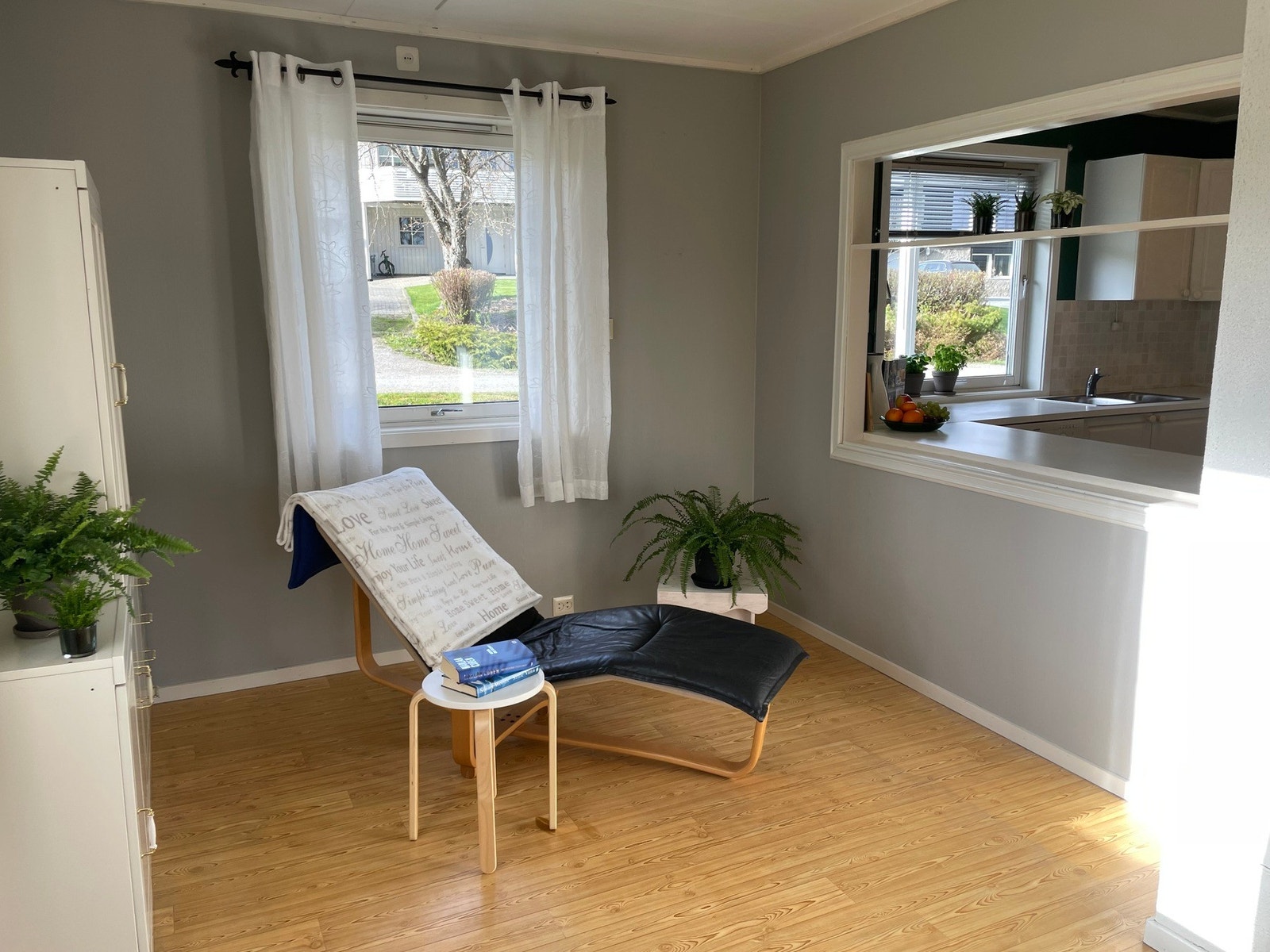 Stue med delvis åpen løsning mot kjøkken, med åpning til høyre i bildet. Galleribilde