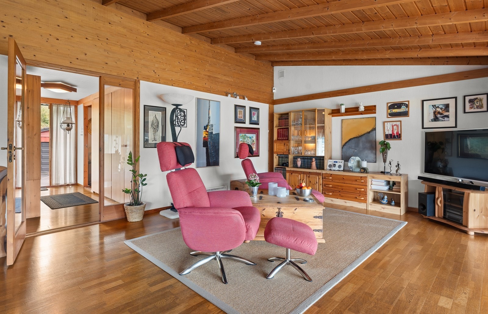 Stue har peis og varmepumpe til oppvarming i tillegg til varmekabler i gulv i den nye delen. Galleribilde