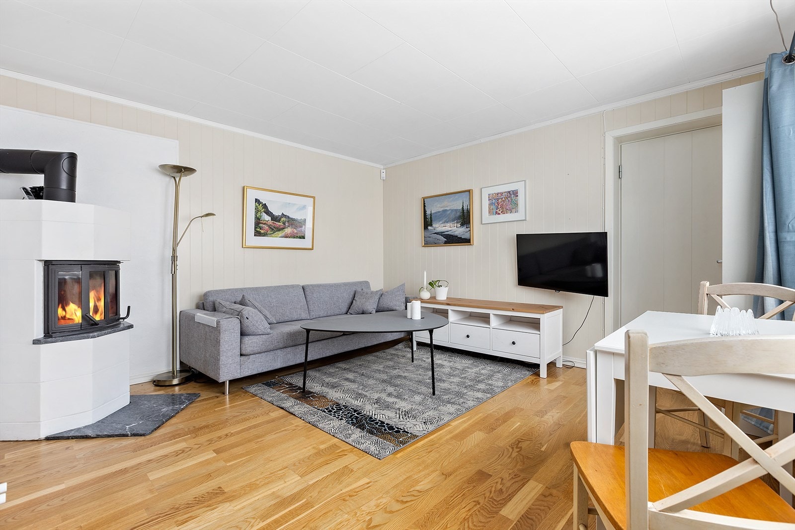 Stue i hybelleiligheten har også vedovn. Dør ut til garasjen til høyre Galleribilde