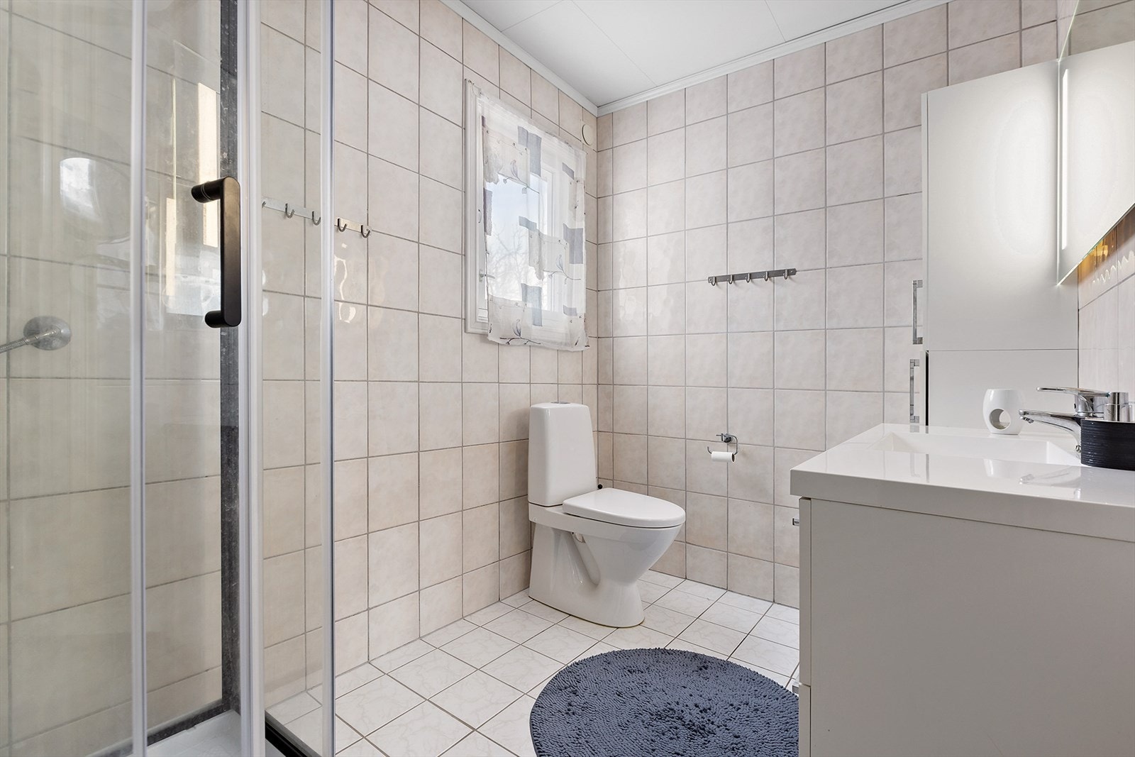 Bad i hovedetasjen med dusjkabinett, toalett og innredning med servant Galleribilde