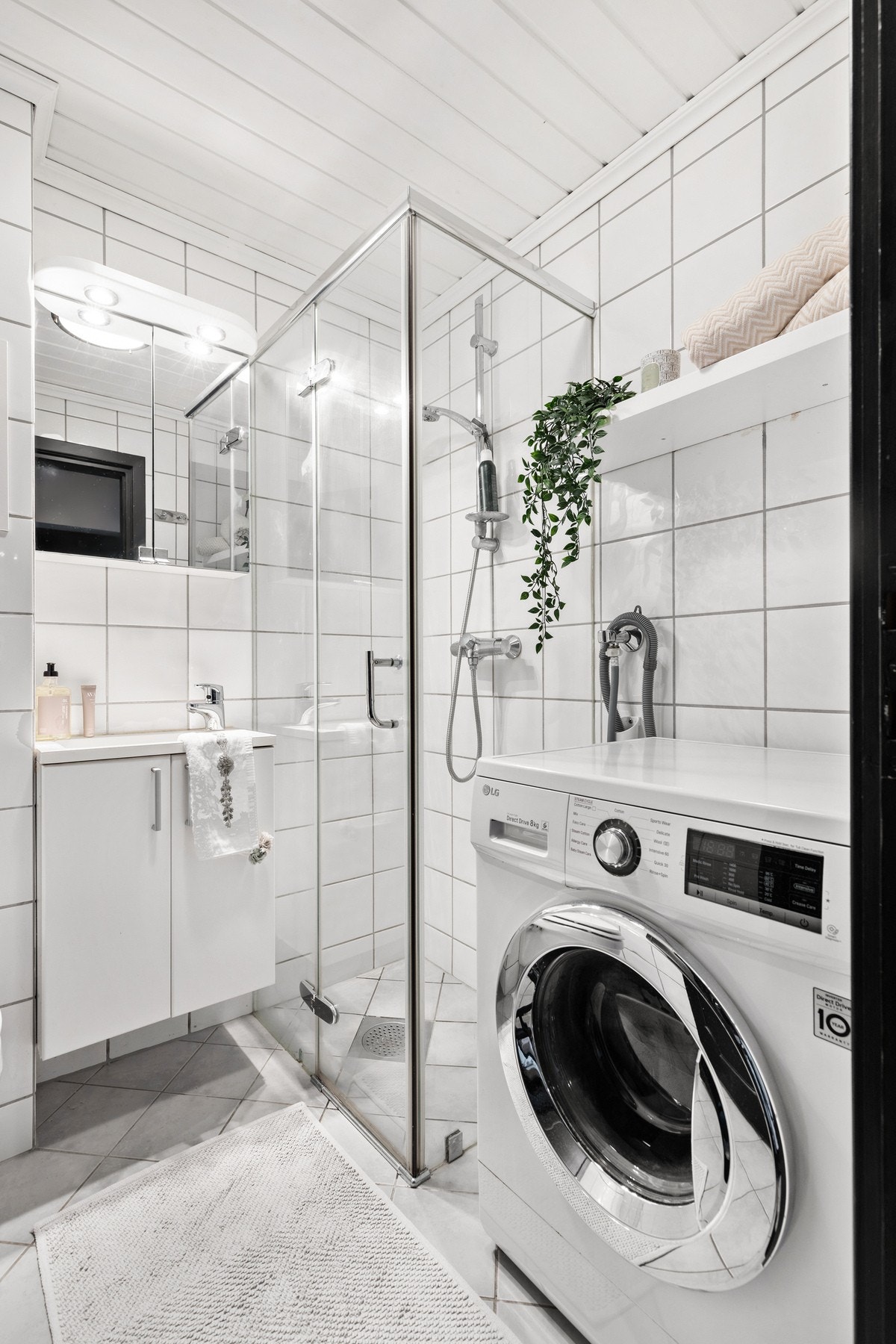 Dusjhjørnet er avgrenset med glassdør og har veggmontert dusjarmatur Galleribilde