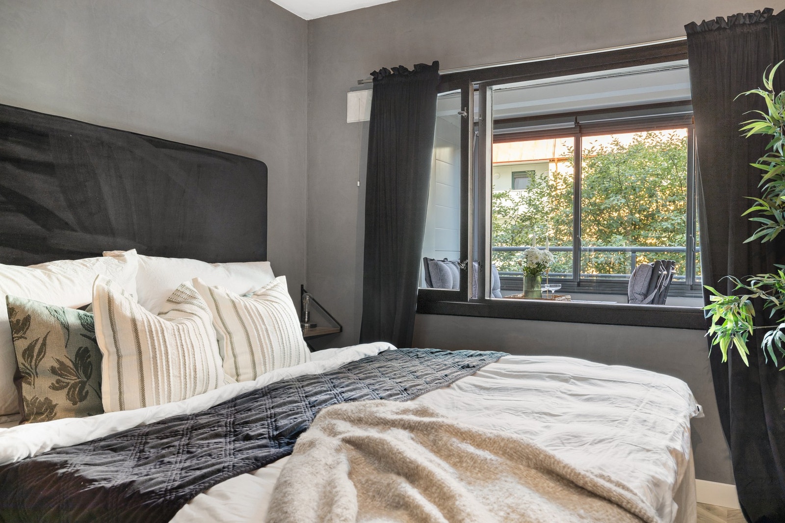 Lite innsyn til soverommet og flott utsyn over grønne trær på sommerstid Galleribilde