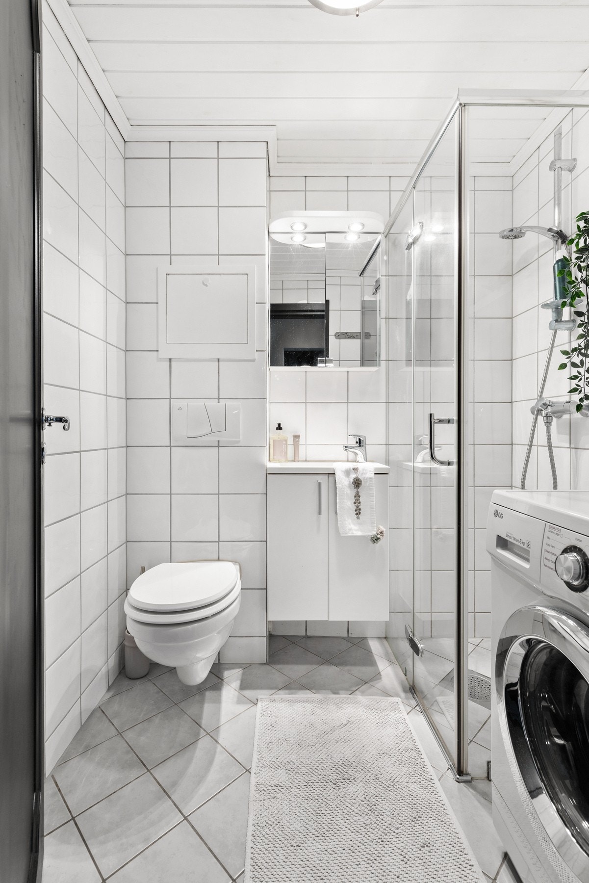 Rommet er innredet med vegghengt servantskap. Over servanten er det montert speilskap med overlys og stikkontakt Galleribilde