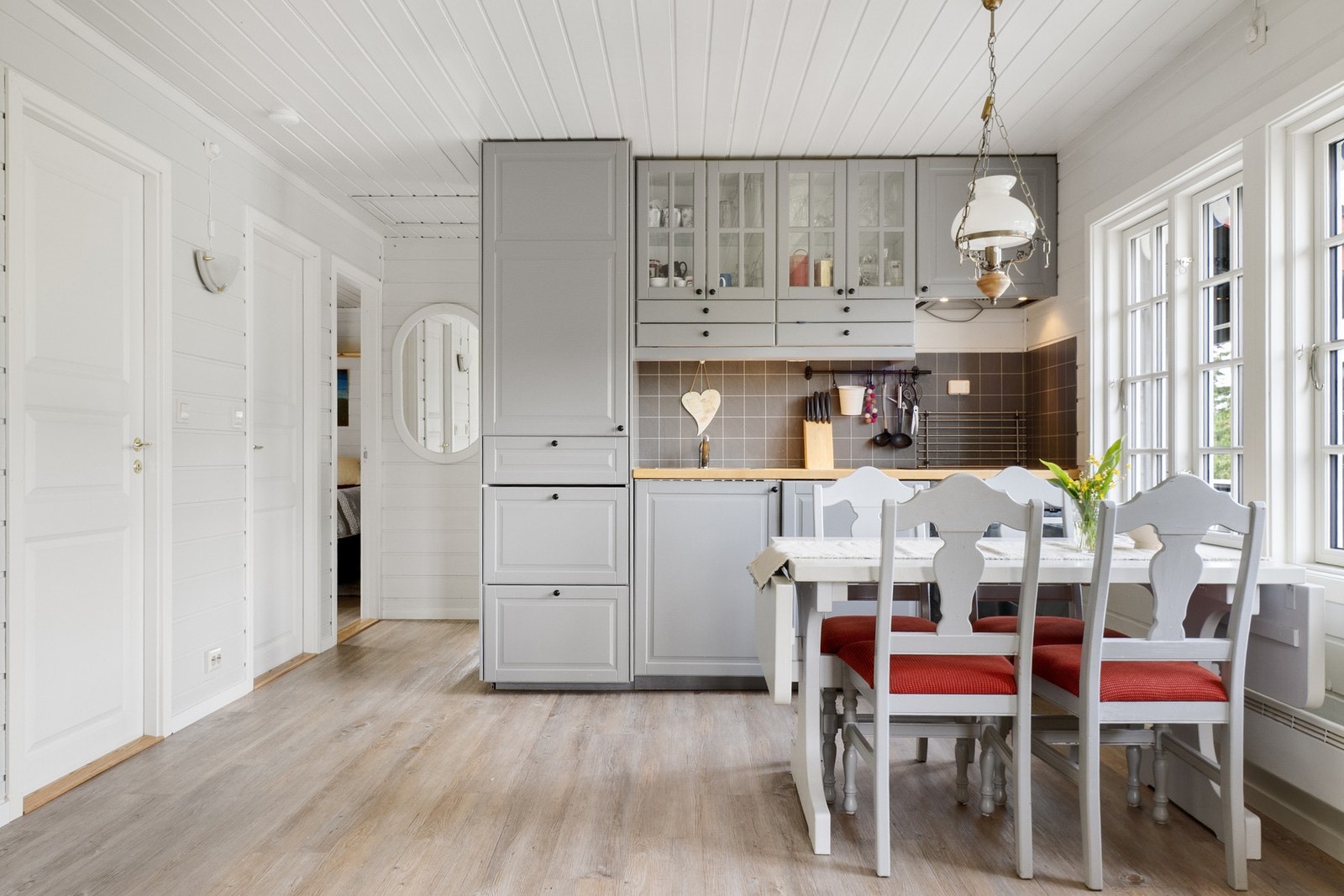 Nytt gulv belagt med laminat. Laminert plate mellom kjøkkenbenk og overskap. Galleribilde