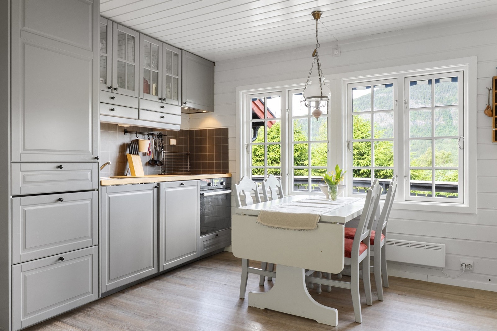 Benkeplate av tre. Integrert stekeovn, platetopp, oppvaskmaskin og kjøleskap. Ventilator i overskap med komfyrvakt. Galleribilde