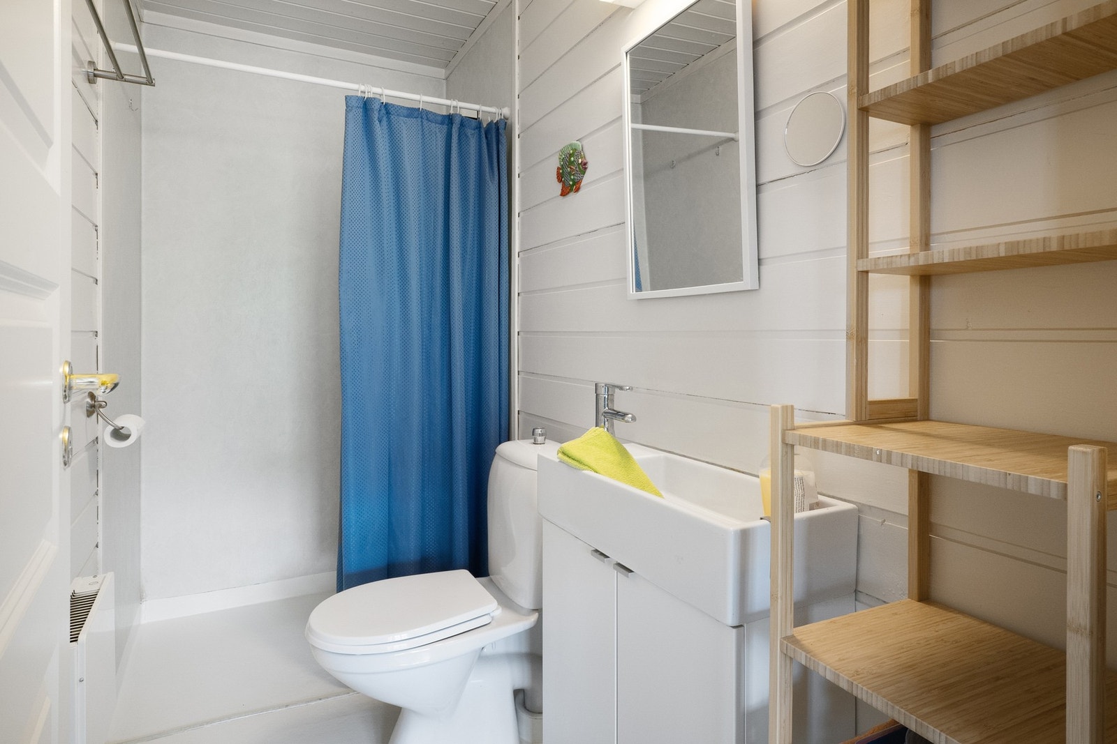 Bad til venstre: Malte panelbord i himling. Vegghengt servantinnredning. Dusjhjørne med forheng. Gulvstående toalett. Mekanisk avtrekksvifte i himling. Galleribilde
