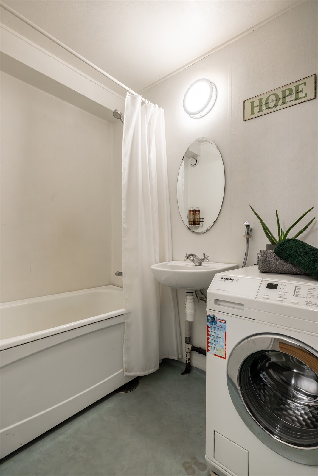 Badet er utstyrt med to servanter, frittstående badekar, opplegg for vaskemaskin og varmtvannsbereder. Galleribilde